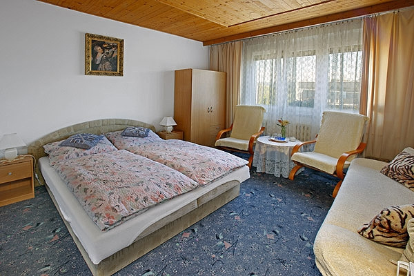 Dvoulůžkový pokoj s manželskou postelí.